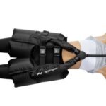 Accesorio de cadera Normatec puesto sobre la zona pélvica de una persona, con manguera conectada visible