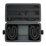 Maleta Hyperice Normatec abierta, mostrando compartimentos interiores con mangueras negras enrolladas y bolsillos elásticos en la tapa
