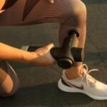 Aplicando la Hypervolt 2 Pro de Hyperice en el tobillo de una deportista, al aire libre