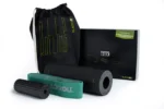 Componentes del kit Running Box sobre fondo blanco: bolso Keep Rolling, rodillo Slim negro, Mini Flow verde y Loop Band