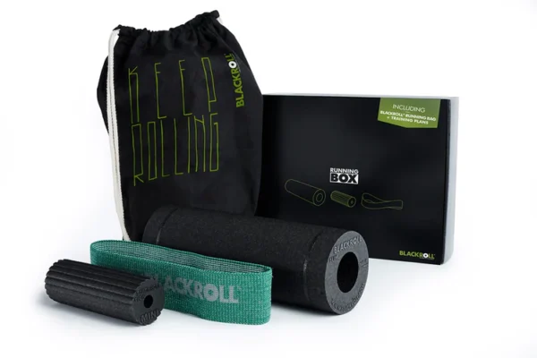 Componentes del kit Running Box sobre fondo blanco: bolso Keep Rolling, rodillo Slim negro, Mini Flow verde y Loop Band