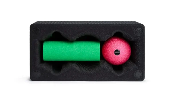 Blackroll Block visto de frente con los compartimentos abiertos, rodillo Mini verde y Ball 08 rosada insertados