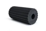 Foam roller Blackroll Flow negro con superficie de bordes bidireccional, vista en ángulo sobre fondo blanco