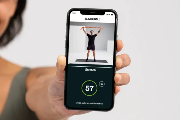 Mano sosteniendo un celular con la app Blackroll mostrando un ejercicio de estiramiento con contador
