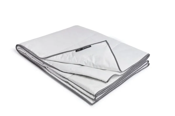 BR_2024-11_RECOVERY_BLANKET_SUMMER_01962_WEB Blackroll Recovery Blanket Summer doblada, manta gris claro con ribete oscuro