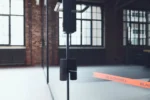 Interior de un estudio con equipamiento de entrenamiento y una banda elástica naranja de Blackroll en el piso, ambientación de gimnasio