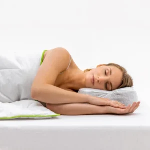 Mujer durmiendo de lado sobre almohada con funda Allergoprotect y ribete verde