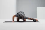 Hombre en plancha con el antebrazo apoyado sobre el Blackroll Twin