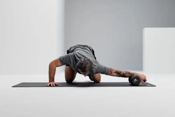 Hombre en plancha con el antebrazo apoyado sobre el Blackroll Twin