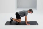 Hombre en posición de cuadrupedia apoyando la rodilla sobre el Blackroll Twin