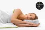 Mujer durmiendo de lado sobre la Blackroll Recovery Pillow, con insignia de postura recomendada de lado