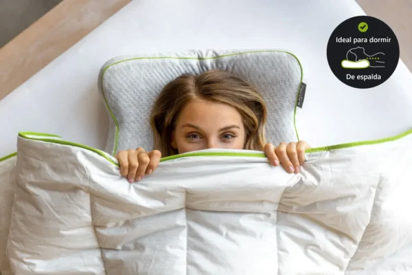 Vista cenital de mujer asomada bajo la manta con la Blackroll Recovery Pillow detrás de la cabeza