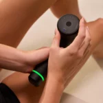 Primer plano de manos ajustando el dial de velocidad del Hypervolt 3 sobre el antebrazo