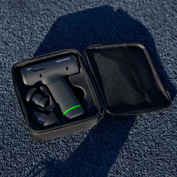 Hypervolt Go 3 con sus 2 cabezales intercambiables dentro del estuche de transporte abierto